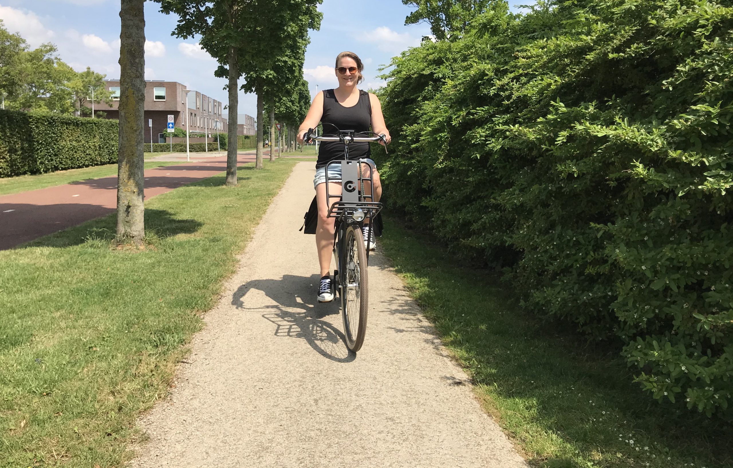 Vrouw in zomerse kleding op fiets