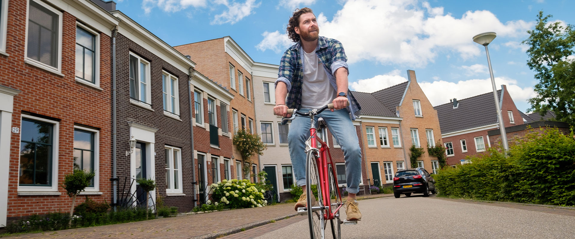 Jonge man op hippe fiets in woonwijk